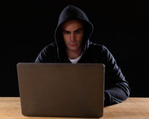Man In Hood Using Computer